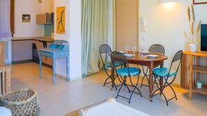 A compact living space with a dining area, kitchenette, and a small seating area.
