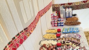 A tented area with a table displaying various food items and condiments. - White Desert Camp Safari (Al Bawiti)