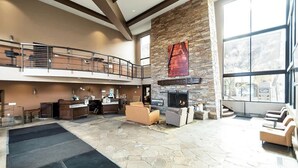 A spacious lobby with a fireplace, seating area, and a balcony. - Charming Park City Loft and View at Prospector (Park City)