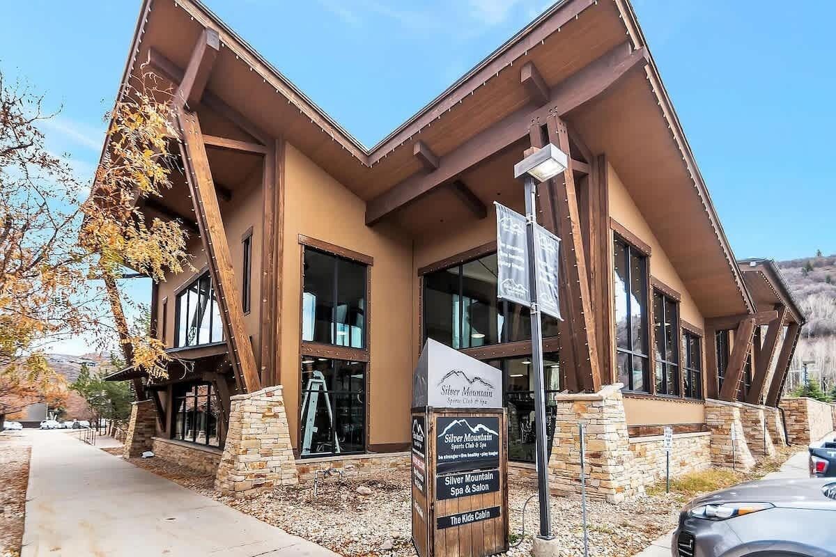 Un edificio con fachada de piedra, amplios ventanales y un cartel que dice 'Silver Mountain Spa & Salon'.