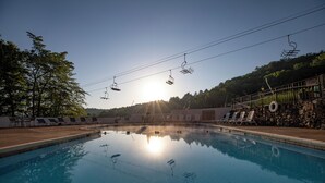 Ein Schwimmbecken mit Liegestühlen und einer Steinmauer.