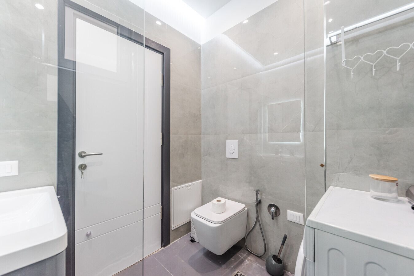 Een moderne badkamer met toilet, bidet en wastafel.