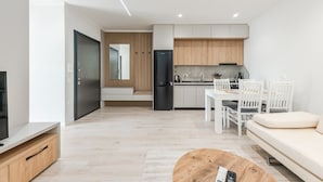 Una sala de estar moderna con televisor, sofá y mesa de centro.