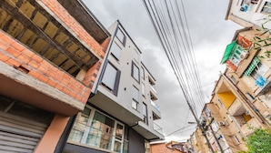 Un edificio de varios pisos con fachada moderna, ventanas grandes y balcones visibles.