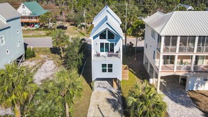 Um imóvel costeiro com uma casa central com varanda, cercado por outras construções e uma área arborizada.