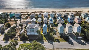 Uma área residencial costeira com casas ao longo da praia, apresentando diversos estilos e cores arquitetônicas.