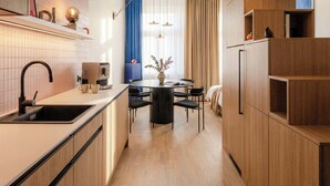 Une cuisine moderne dotée d’un îlot central, de meubles en bois et d’un coin repas avec une table ronde et des chaises.