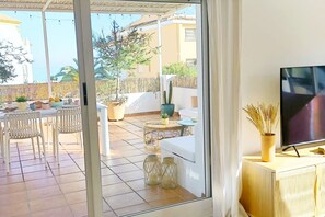 Ein Zimmer mit einer Schiebetür aus Glas, die auf eine Terrasse im Freien führt.