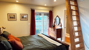Un dormitorio con cama, cómoda y una escalera de madera.
