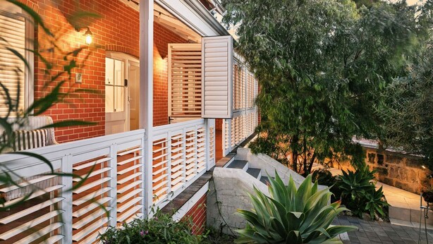 A brick house with a white porch and a small staircase leading to a deck. - North Fremantle Retreat | Walk to Beach, River & Train (North Fremantle)