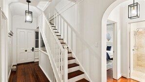 A staircase with white railings leading to a bedroom with a shower. - North Fremantle Retreat | Walk to Beach, River & Train (North Fremantle)