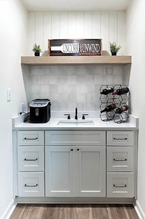 A kitchen with a white countertop, a toaster, a wine rack, and a sign above the counter. - Modern 3-bedroom 2 bath house (Lawrenceville)