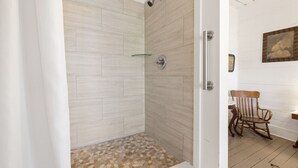 A shower with a tiled floor and a door with a handle. - The Historic Island Hotel of Cedar Key (Cedar Key)