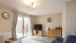 A cozy living room with a sofa, a television, and a wooden cabinet. - Sarah`s House: BBQ Parking 10mins To Alton Towers (Alton Towers & Staffordshire Villages)