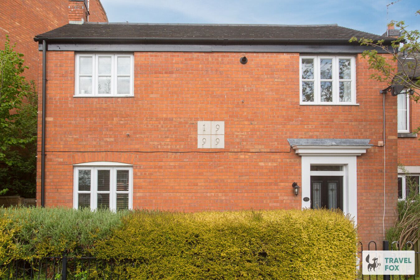 A red brick house with two windows and a door, numbered 19 and 29.