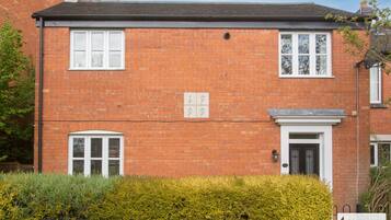 A red brick house with two windows and a door, numbered 19 and 29.