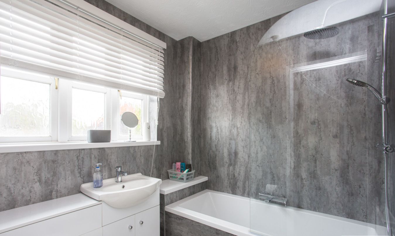A modern bathroom with a large bathtub, a shower, and a vanity with a sink.