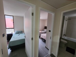 Ein Zimmer mit einem Bett, einem kleinen Schreibtisch und einem Fenster.
