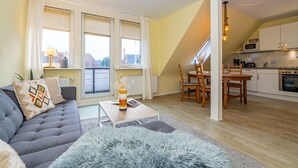 A modern apartment with a living room, dining area, and kitchen. - Tom - 3-room vacation apartment on the 1st floor in Westerland with terrace. (Sylt)