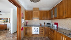 Una cocina con armarios de madera, horno empotrado y encimera de granito.