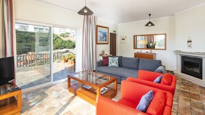 Una sala de estar con sofá, mesa de centro, televisor y chimenea.