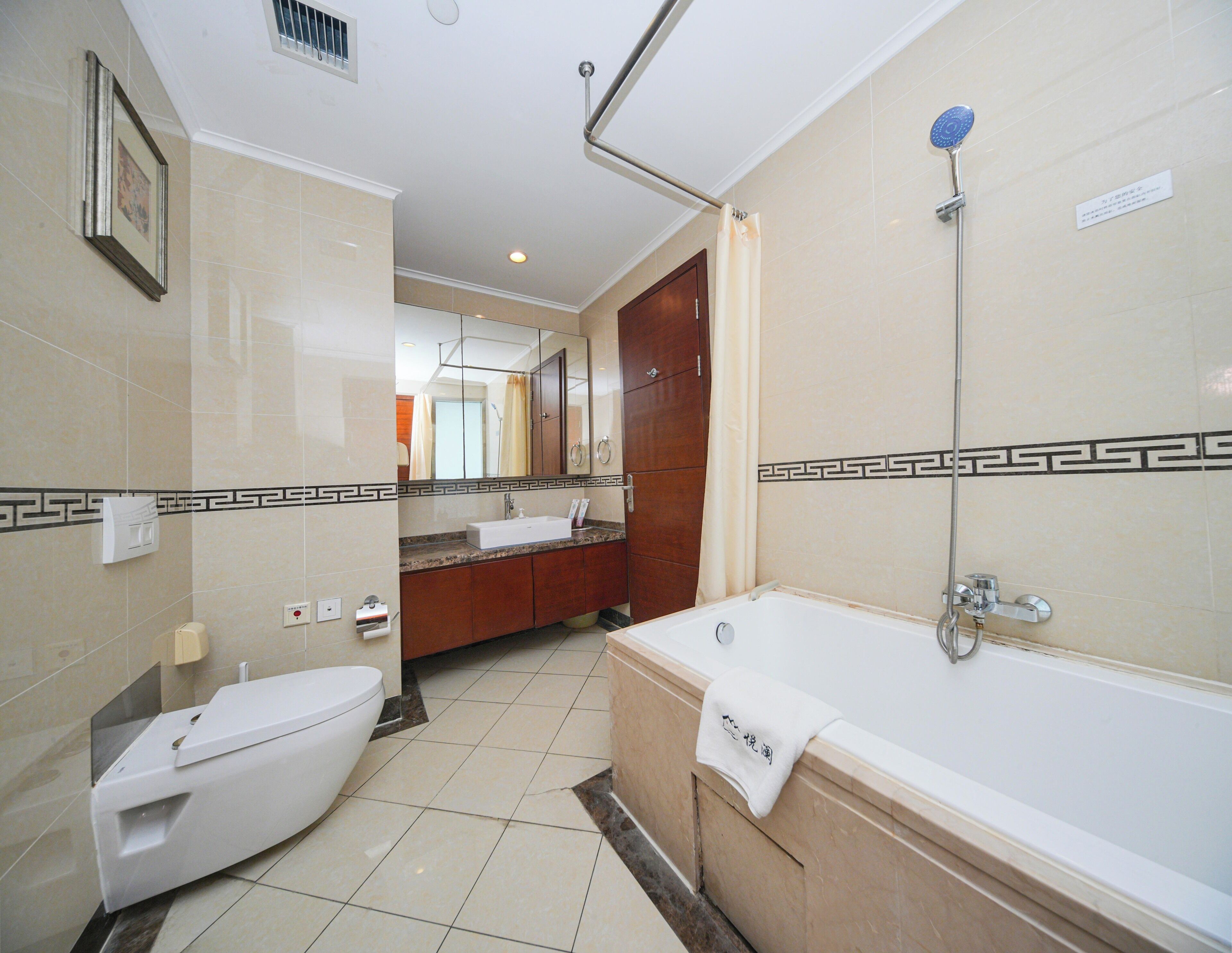 A modern bathroom with a toilet, sink, and bathtub.