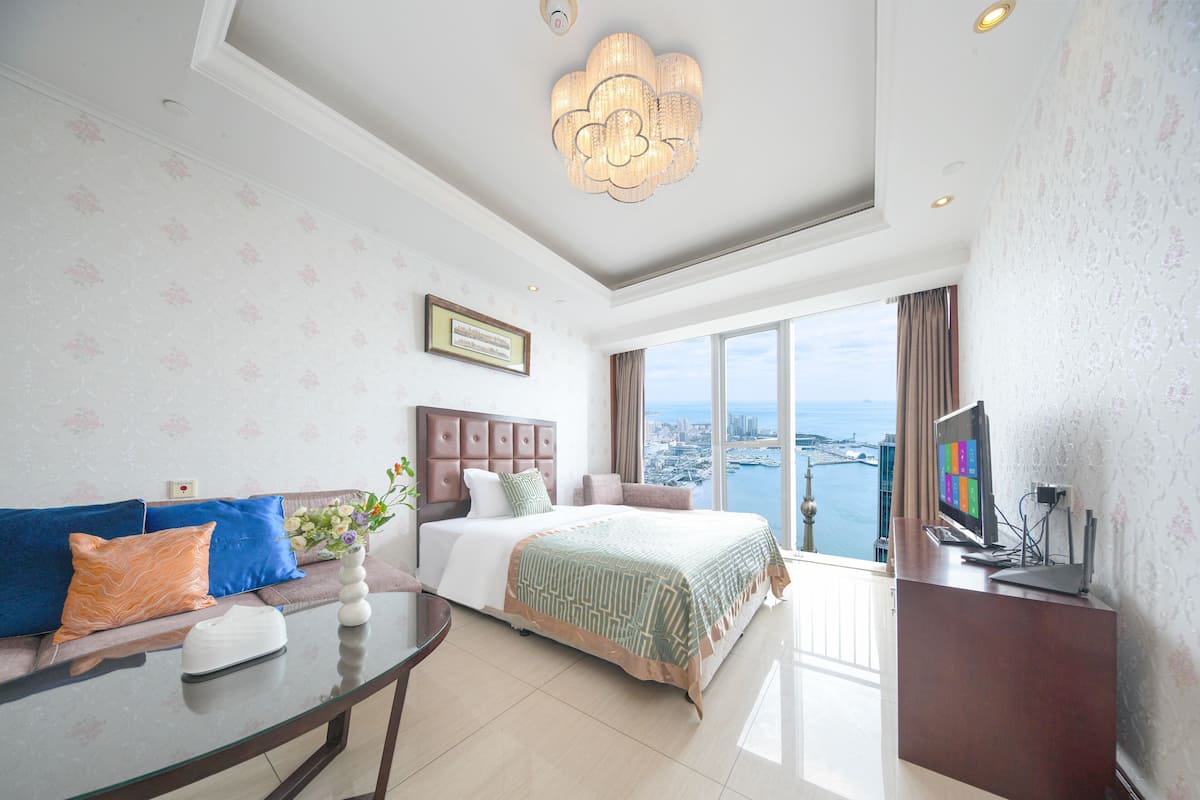Une chambre d’hôtel moderne équipée d’un grand lit, d’un canapé, d’une table à manger et d’un téléviseur.
