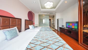 Una habitación de hotel con una cama grande, televisión y minibar.