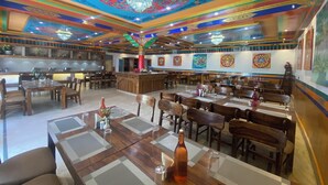 Ein geräumiges Restaurant mit hohen Decken, aufwendiger Deckenverzierungen und traditioneller Wandmalerei.