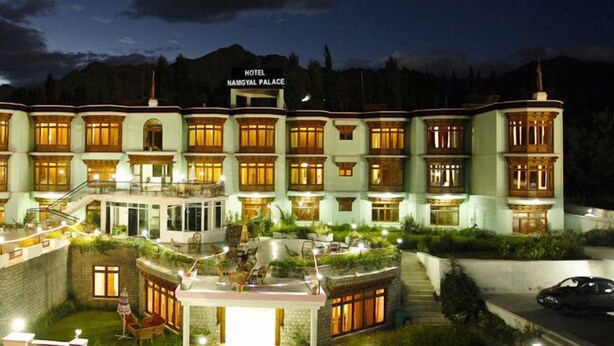 Ein mehrstöckiges Hotel mit einem Schild, auf dem 'Hotel Namgyal Palace' steht.