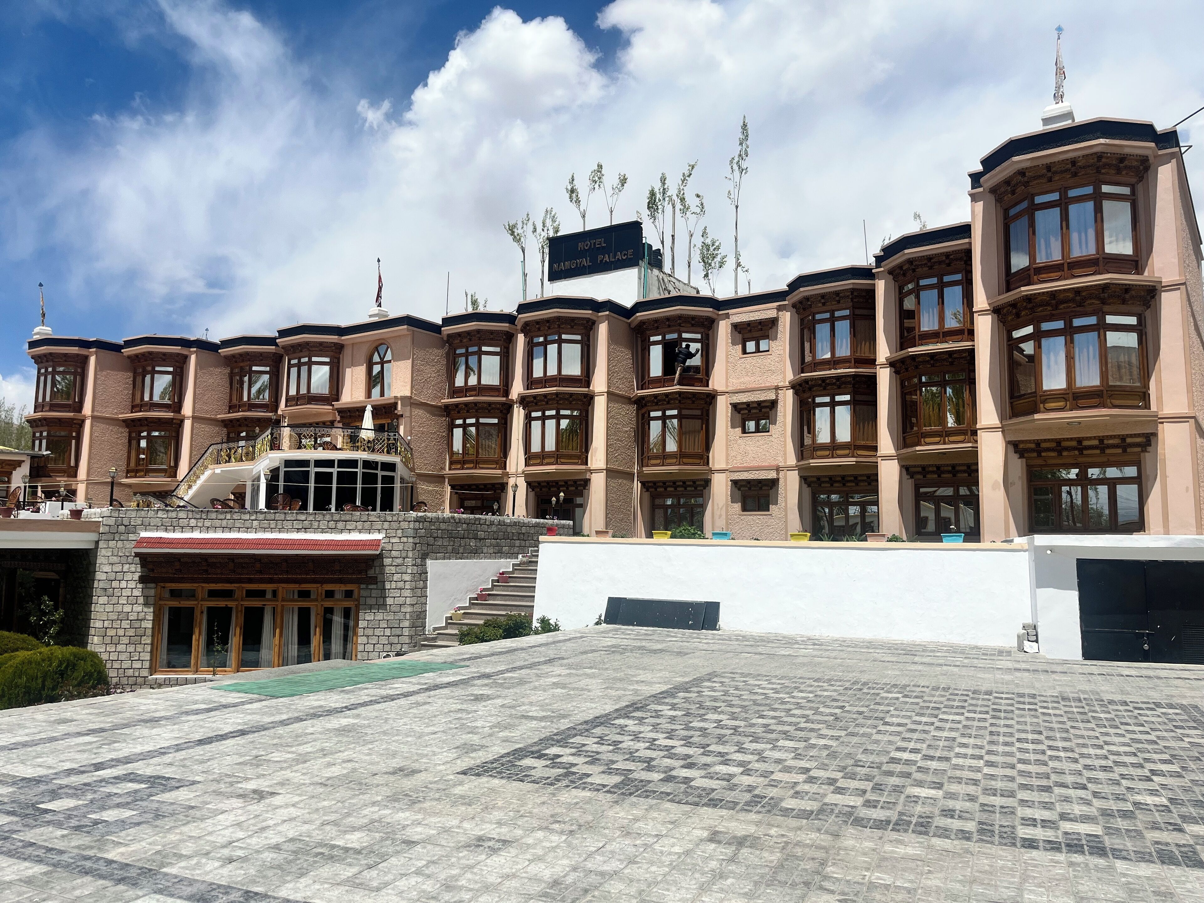 A large, multi-story hotel with a prominent entrance, a balcony, and a sign indicating it is a hotel.