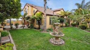A house with a well-maintained garden, including a fountain and various plants. - Acanto Del Mar (Aptos)