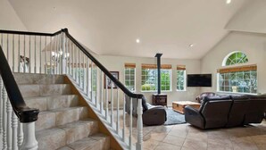 A spacious living area with a staircase, a fireplace, and a large leather sofa. - Acanto Del Mar (Aptos)