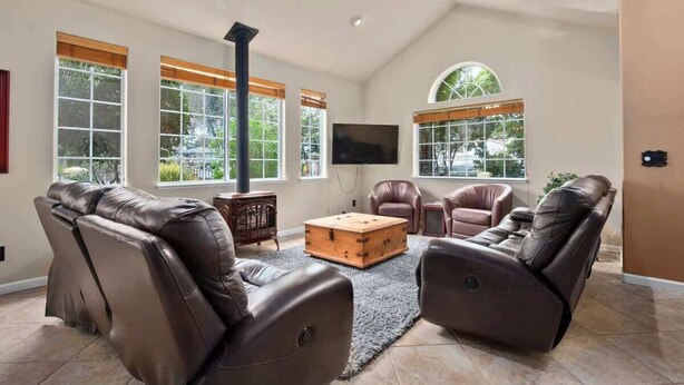 A spacious living room with leather recliners, a wooden coffee table, and a fireplace. - Acanto Del Mar (Aptos)