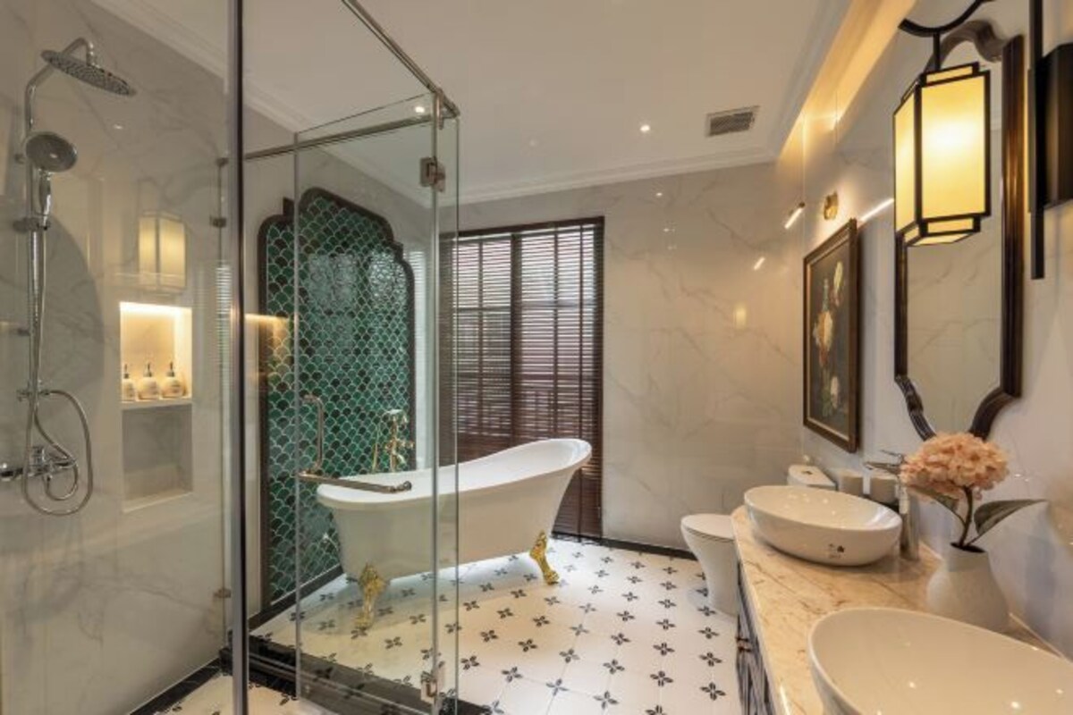 Une salle de bain moderne avec une douche à parois de verre, une baignoire sur pieds et un lavabo rond.
