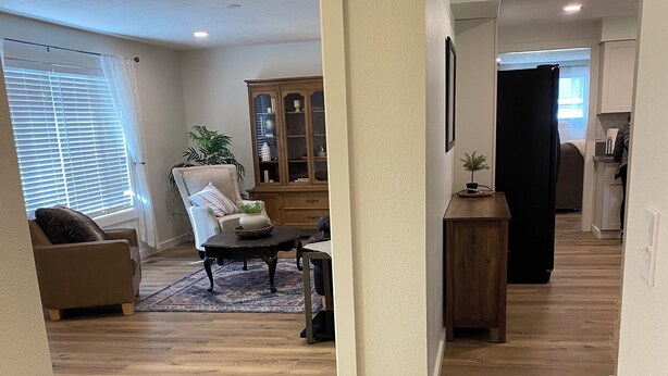 Amplia sala de estar con piso de madera, un mueble de madera grande y una zona de estar acogedora.