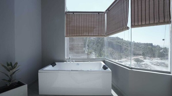 A modern bathroom with a freestanding bathtub, large windows, and a potted plant. - R D S Nature Retreat (Anekal)