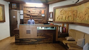 Una recepción con diseño de madera, un extintor y una pared con un relieve de elefantes.