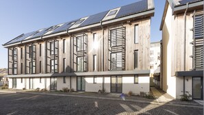 Ein modernes Gebäude mit Flachdach, großen Fenstern und Solaranlage.