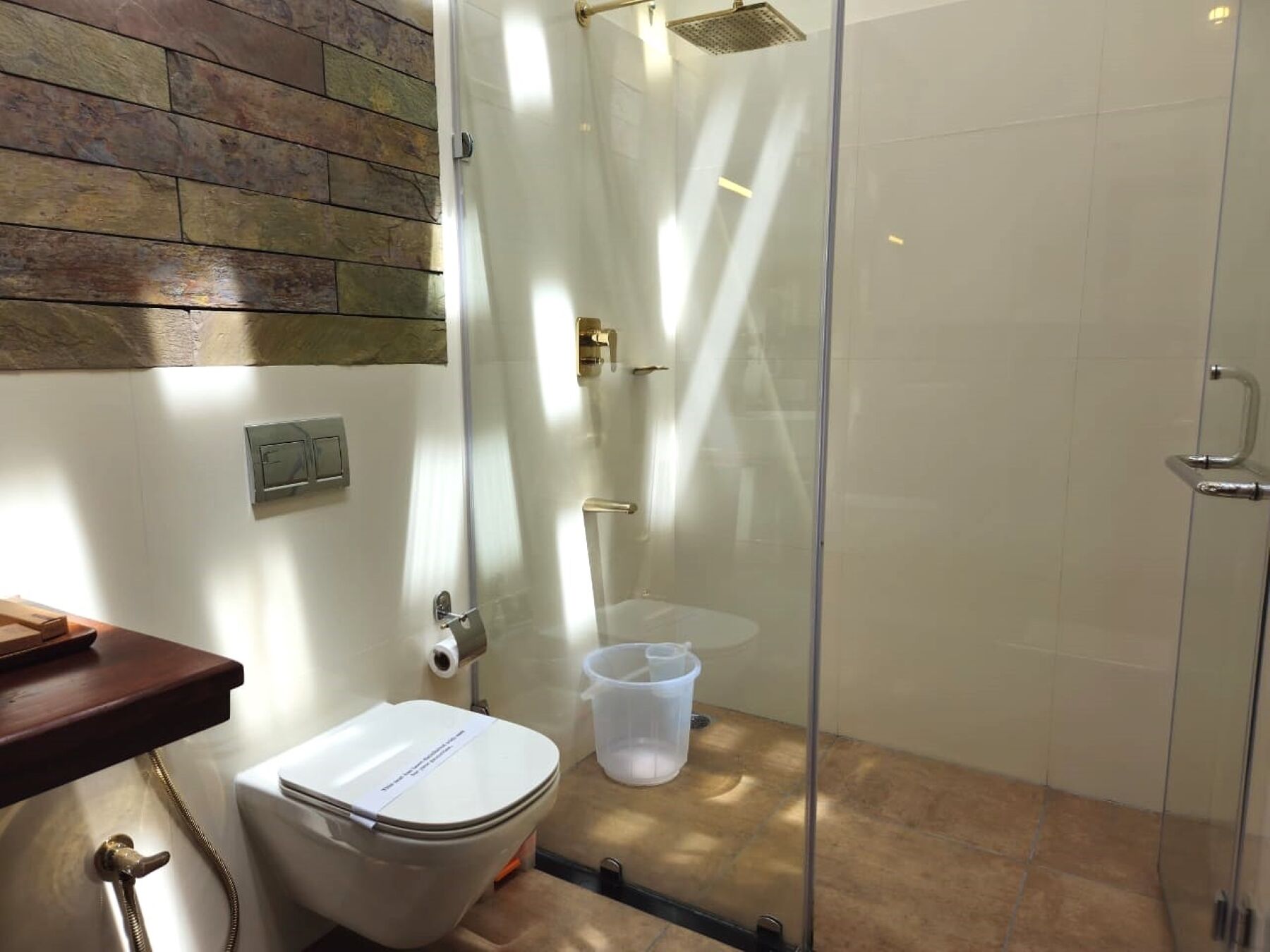 Ein Badezimmer mit Toilette, Dusche und einer Glaskabine zur Dusche.