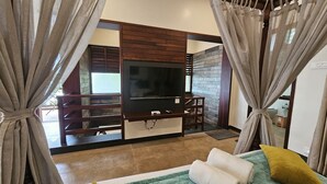 A bedroom with a TV, wooden furniture, and curtains. - The Story Resorts & Spa (Yercaud)
