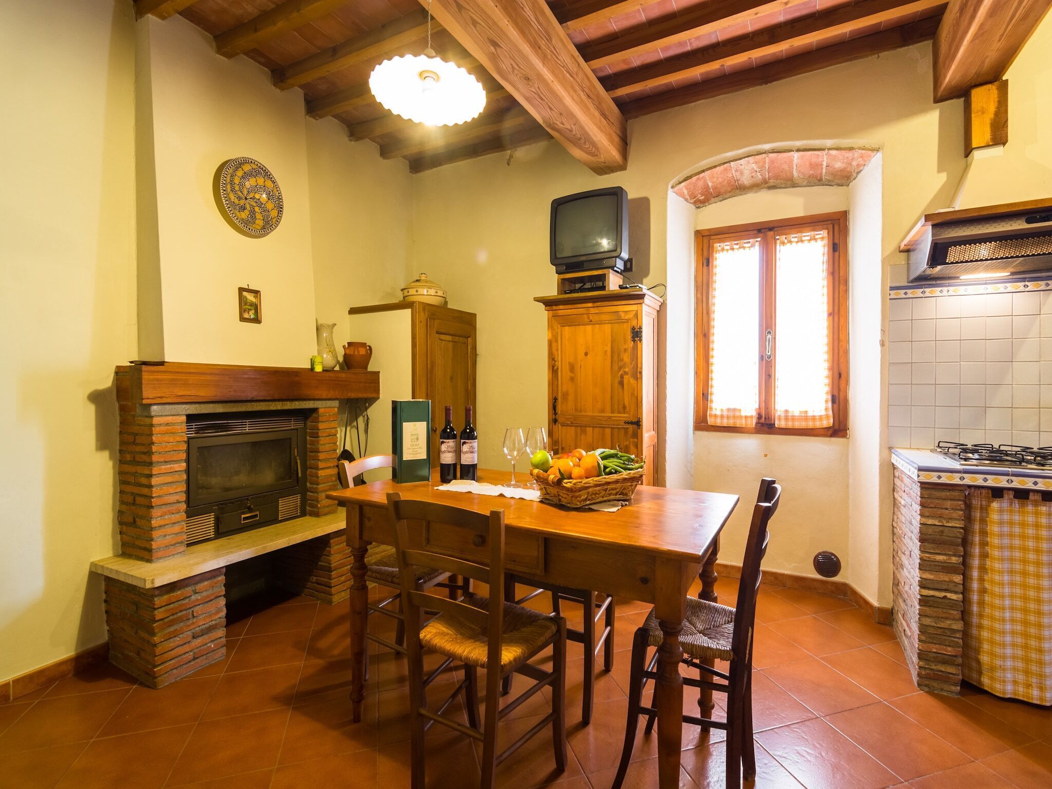 Una cocina acogedora con chimenea de ladrillo, mesa de comedor de madera y salpicadero de azulejos.