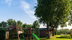Ein Spielplatz mit Rutsche, Schaukeln und einem Basketballkorb.