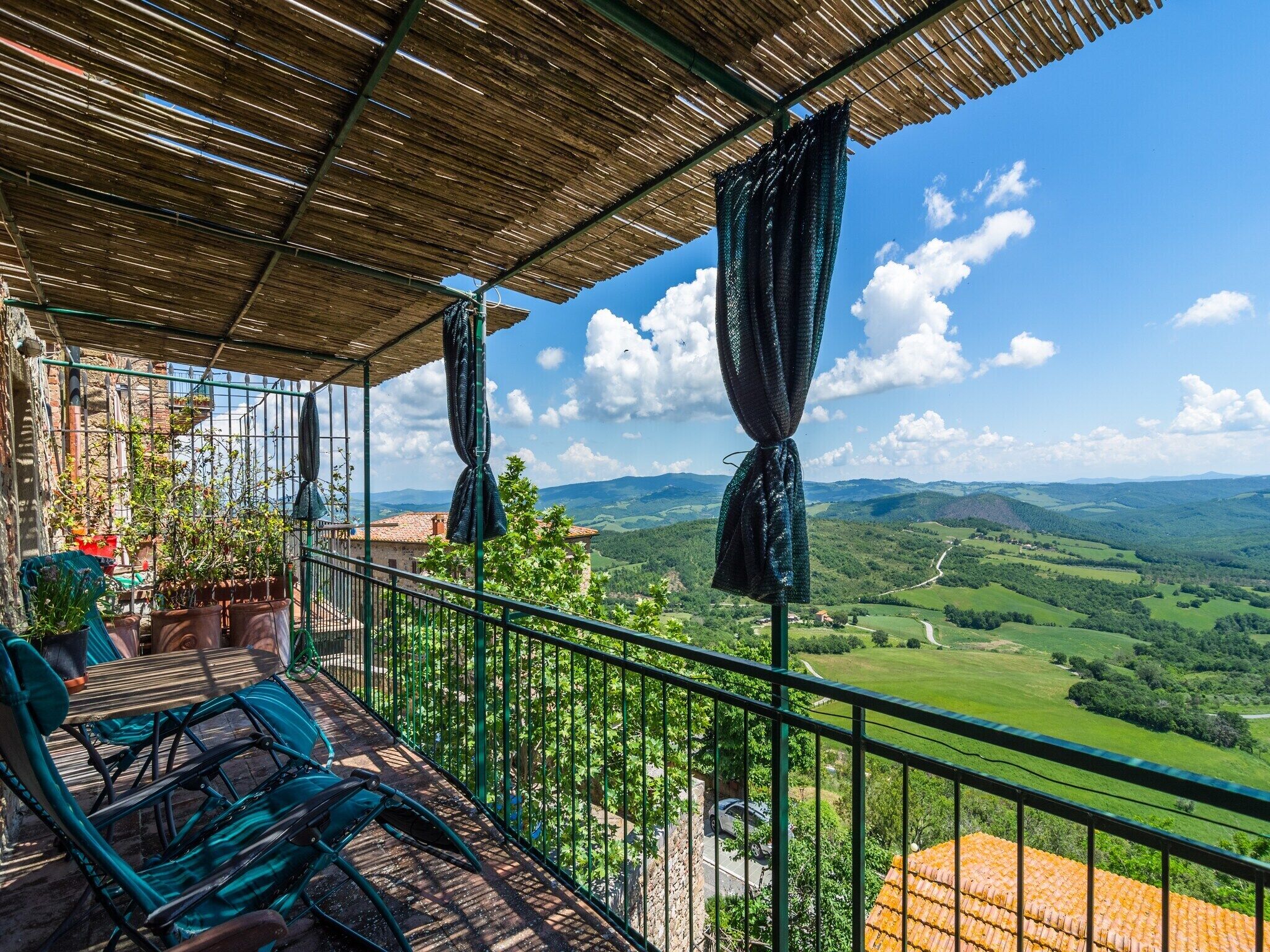 A balcony with a view of rolling hills and a clear sky.