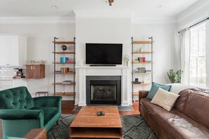 TV connectée, cheminée, livres, chaîne hi-fi