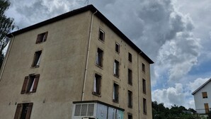 A multi-story building with a beige facade, multiple windows, and a visible antenna on the roof. - Lovely studio 15min walk from Epinal town center (Chantraine)