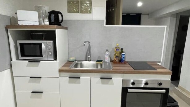 A compact kitchen with a microwave, sink, and oven. - Room in Angers near the streetcar with shared kitchen and bathroom (Angers)