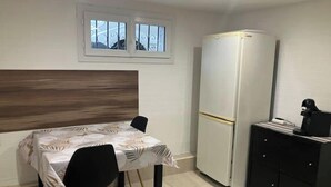 A small kitchenette with a refrigerator, a coffee machine, and a black cabinet. - Room in Angers near the streetcar with shared kitchen and bathroom (Angers)