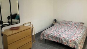 A bedroom with a bed, a dresser, a mirror, and a nightstand. - Room in Angers near the streetcar with shared kitchen and bathroom (Angers)