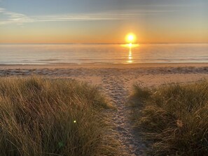 A beach path leading to the ocean with a sunset in the background. - Super cozy holiday home in Marielyst (Væggerløse)
